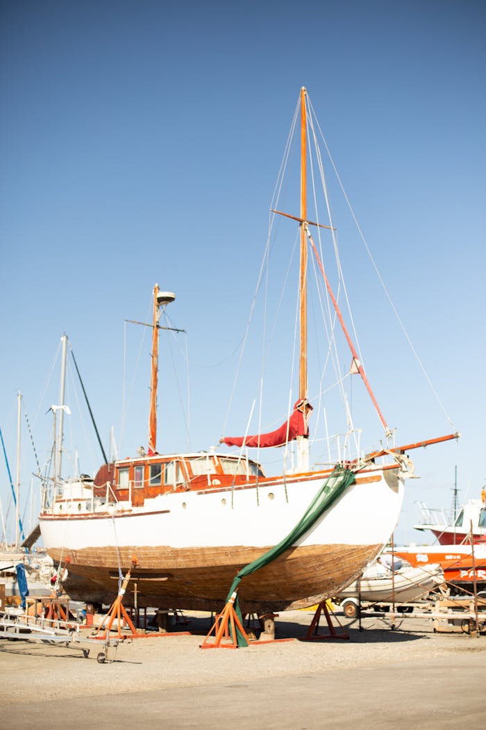 our-services-1 A classic wooden sailboat docked in a Greek shipyard on a sunny day.